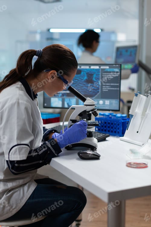 Preview: Specialist biologist researcher analyzing biomedical virus sample using medical microscope