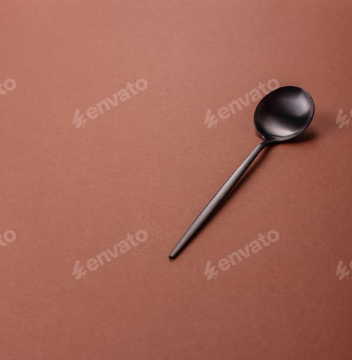 Preview: Empty metal spoon on a monochrome brown background
