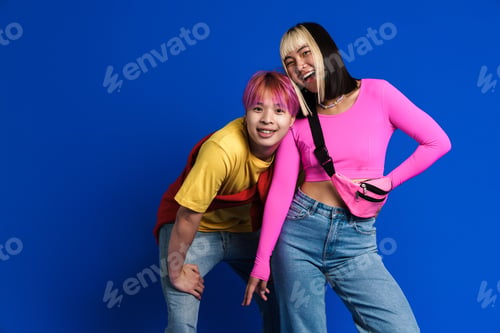 Preview: Asian teenagers with multicolored hair gesturing and laughing together