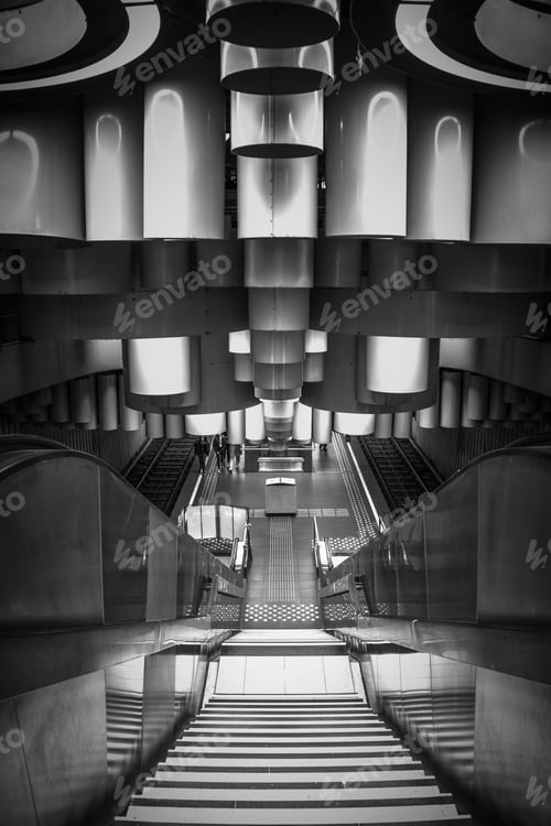 Preview: Vertical grayscale shot of a modern metro station with escalators in Brussels, Belgium