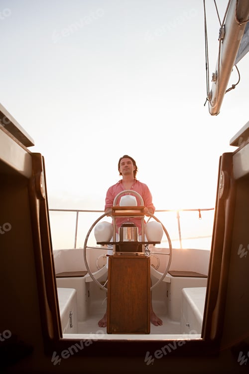 Preview: Mid adult man steering yacht