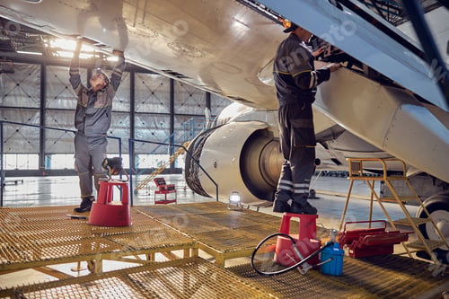 Preview: Engineer working on aircraft wing in aircraft maintenance factory