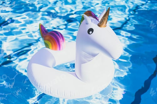 Preview: Inflatable colorful white unicorn at the swimming pool. Vacation time in the swim pool with toys