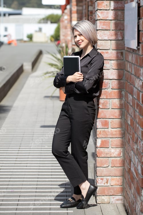 Preview: A young woman stands with a folder of documents in the city. The concept of a business woman