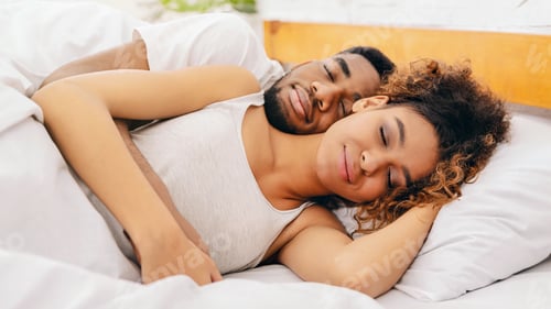 Preview: Couple cuddling peacefully in their sleep in bed