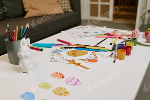 Preview: Easter Egg Drawings and Paints Arranged on Table for Holiday Crafting