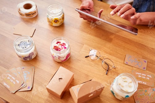 Preview: Close Up Of Man Running Online Business Making Boutique Candles At Home With Digital Tablet