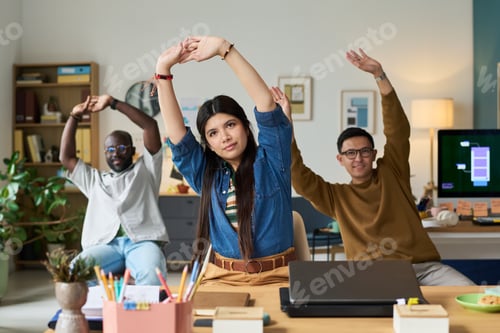 Preview: Diverse Adults Stretching Arms Together during Office Wellness Break