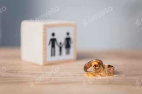 Preview: selective focus of golden rings near wooden cube with family