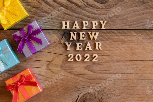 Visualização: Feliz Ano Novo de 2022. Citação feita de letras e números de madeira 2022 sobre fundo de madeira