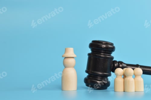 Preview: Wooden doll figures standing with judge gavel. Bribery and corruption concepts