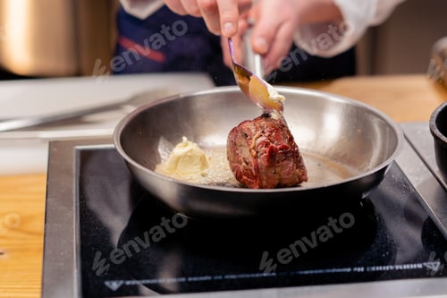 Preview: close-up of seared beef steak with rosemary topped with melted butter in frying pan