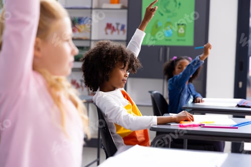 Preview: Happy diverse schoolchildren sitting at desks in school classroom