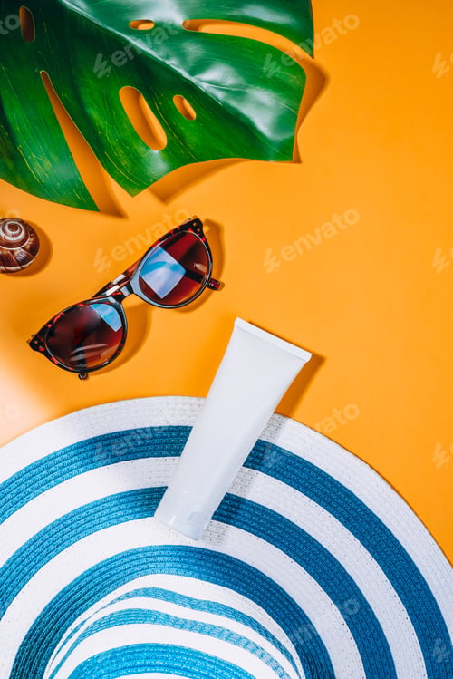Preview: Woman's hat with sunglasses and protection cream SPF on Orange background. Beach accessories.