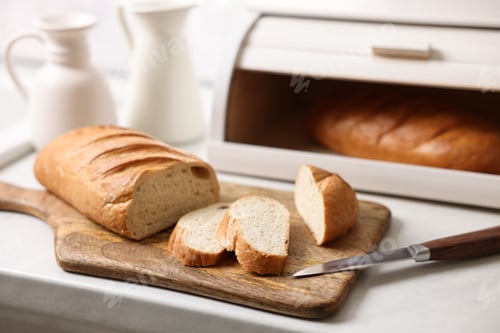 Preview: Wooden bread basket with freshly baked loaves on white marble table in kitchen