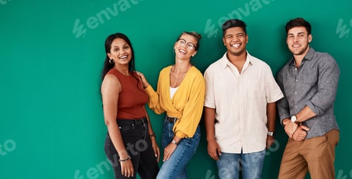 Preview: Portrait of a group of young designers standing together against a green background