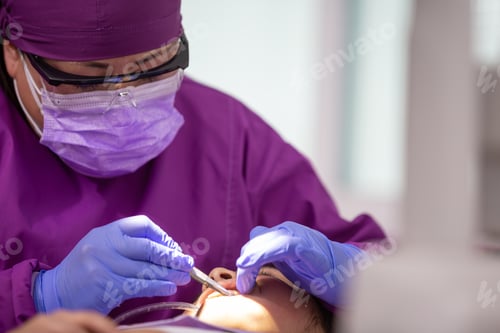 Preview: Closeup of a Mexican female dentist doing dental treatment on the young girl