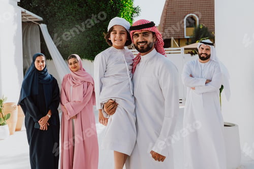 Preview: Emirati family standing together smiling in traditional attire