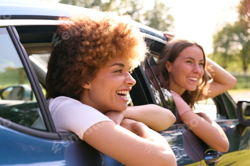 Preview: Two Female Friends Or Same Sex Couple In Car On Road Trip Vacation Together Looking Out Of Window