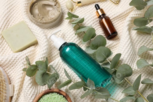 Preview: Composition with spa products and eucalyptus branches on bathrobe, above view