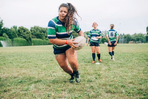 Preview: Focused rugby player running with the ball during a match
