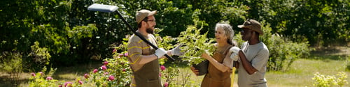 Preview: Middle Aged Caucasian Man Assisting Senior Caucasian Woman and Black Man Gardening
