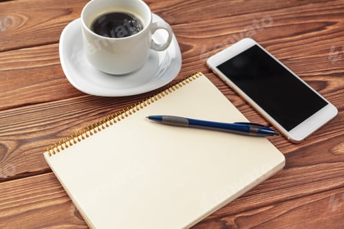 Preview: Writing notes and enjoying coffee while using a smartphone on a wooden table