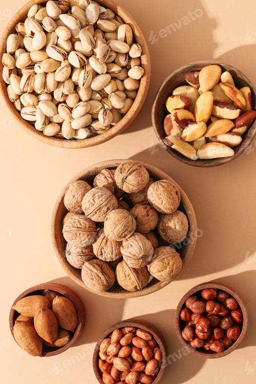 Preview: Nuts in wooden bowls sit on a light surface