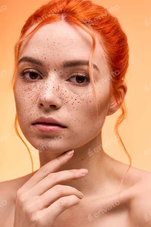 Preview: Stylish young woman with vibrant orange hair and freckles, showcasing her beauty in soft lighting