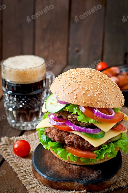 Preview: Big juicy hamburger with vegetables and beef on a wooden background in rustic style