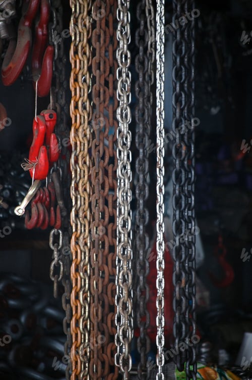 Preview: Vertical selective focus shot of colorful chains and other industrial equipment
