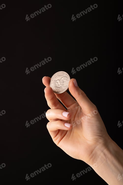 Preview: A woman's hand holds a stack of golden coins Dollars between her fingers,