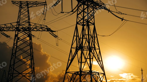 Preview: Electricity poles and electric power transmission lines against vibrant orange sky at sunset