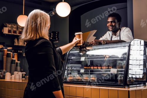 Preview: African barista gives the ordered coffee customer of modern coffee shop