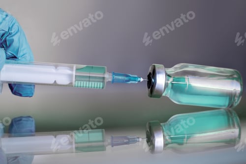 Preview: Vial filled with liquid vaccine in medical lab with syringe.