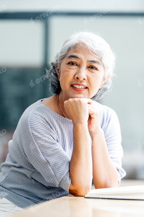 Preview: Senior Woman Smiling with Chin on Clasped Hands