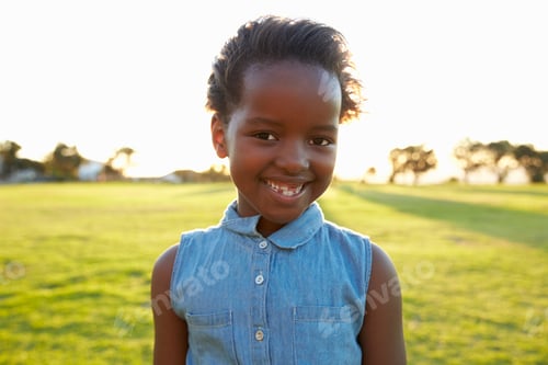 Preview: African elementary school girl smiling in a park, close up
