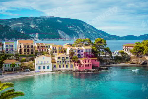 Preview: Assos village. Beautiful view to vivid colorful houses near blue turquoise colored transparent bay