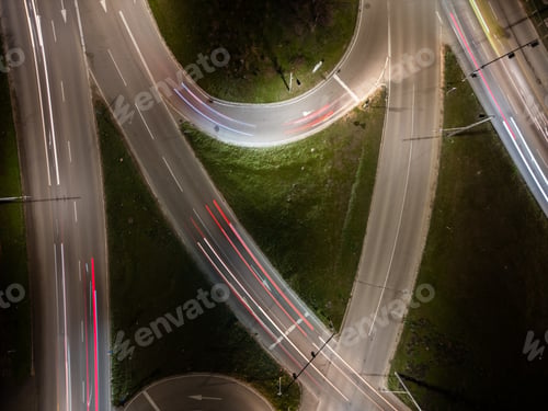 Preview: Top down aerial view of a night intersection with a moving traffic. Vehicles create dynamic light