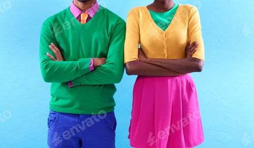 Preview: Cropped studio shot of a two stylishly dressed people standing with their arms crossed