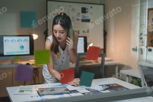Preview: Young businesswoman analyzing marketing data in office at night