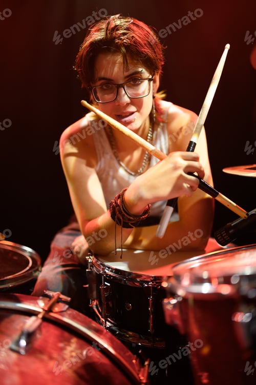 Preview: Drummer leaning on snare drum holding drumsticks in music studio