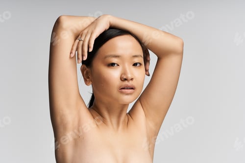 Preview: Confidence radiates from a young beautiful asian woman posing gracefully with her arms raised
