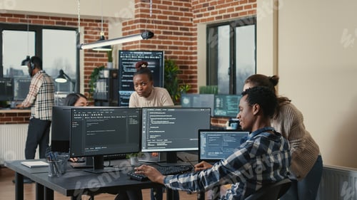 Preview: Programmer analyzing compiling code on multiple screens takes off glasses and doing high five hand