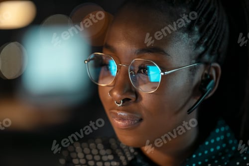 Preview: Smart business woman working with computer while talking with earphone sitting on desktop