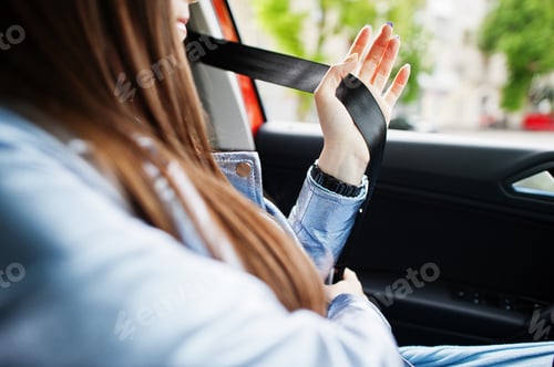 Preview: Gorgeous woman sitting inside car interior and tie belt.