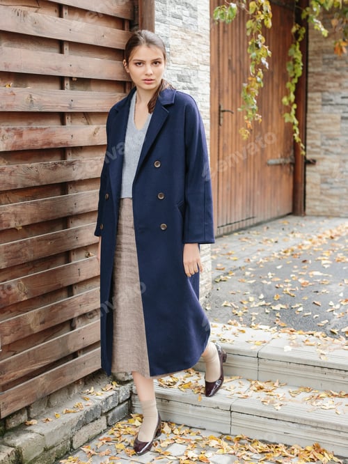 Preview: Happy business woman walking at beautiful autumn city street wearing colorful scarf and warm coat