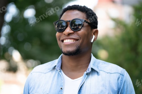 Preview: Man smiling while standing outdoors.