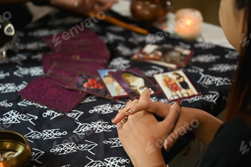 Preview: Cropped shot fortune teller reading tarot cards and predicting the future of young woman visitor