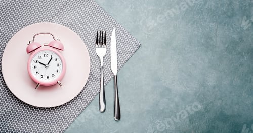Preview: Alarm clock and plate with cutlery. Concept of intermittent fasting, lunchtime, diet and weight loss